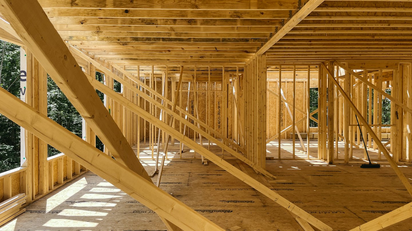 Wooden framing stands inside a house under construction.