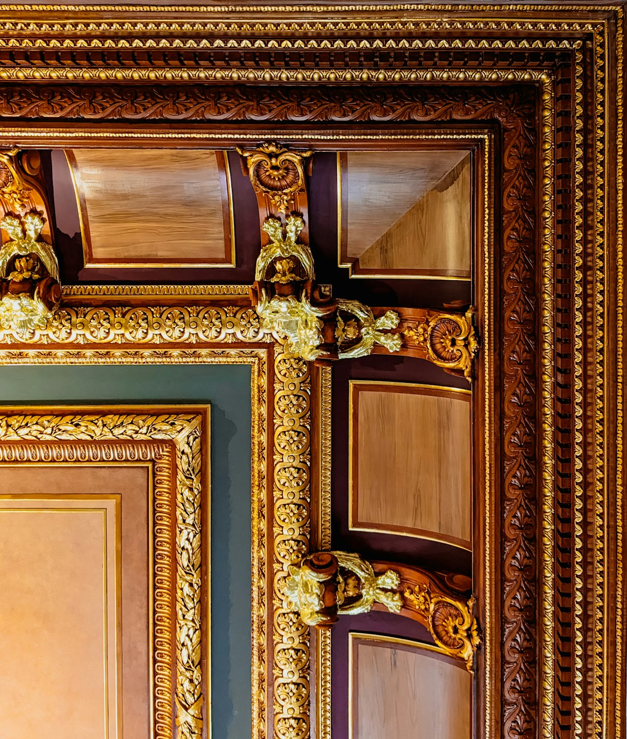 Intricate wooden paneling features gold gilding and classical floral carvings.
